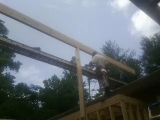 Carpenter setting a ridge beam over a new addition frame — Ice Dam Removal by Roofing Brothers in Channelview