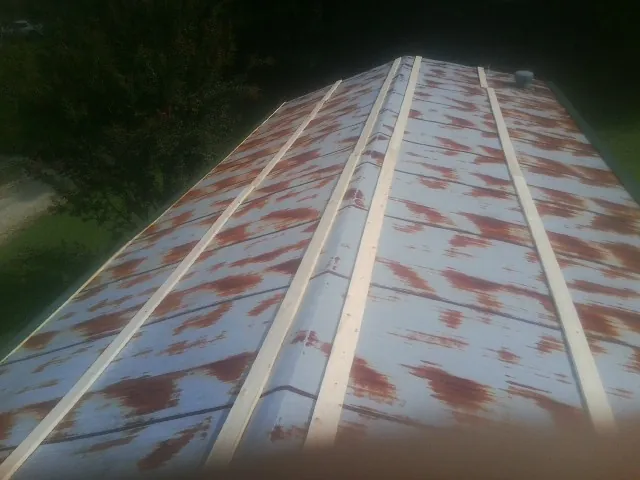 Rusted metal roof panels with new wood purlins before replacement — Storm Damage Roof Repair in Channelview by Roofing Brothers