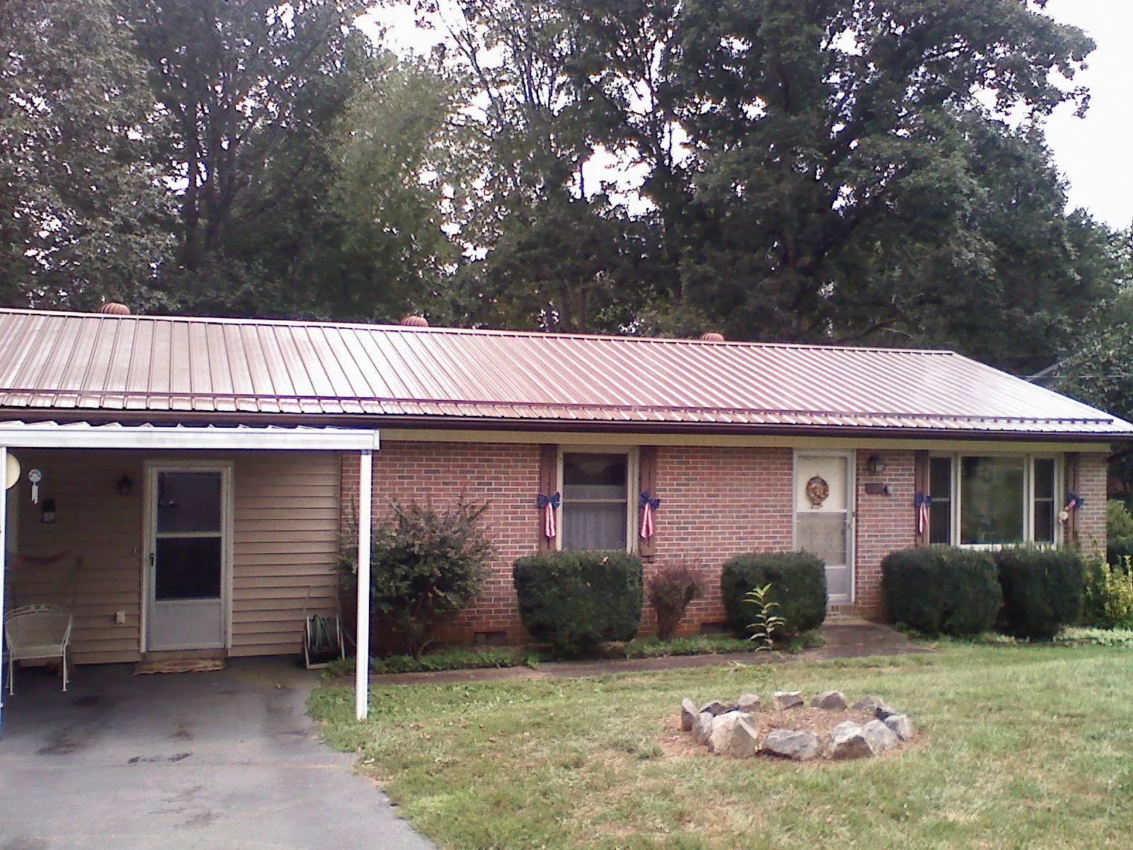 Bronze metal roof and carport on a brick ranch home — Roof Repair work by our crew in Channelview