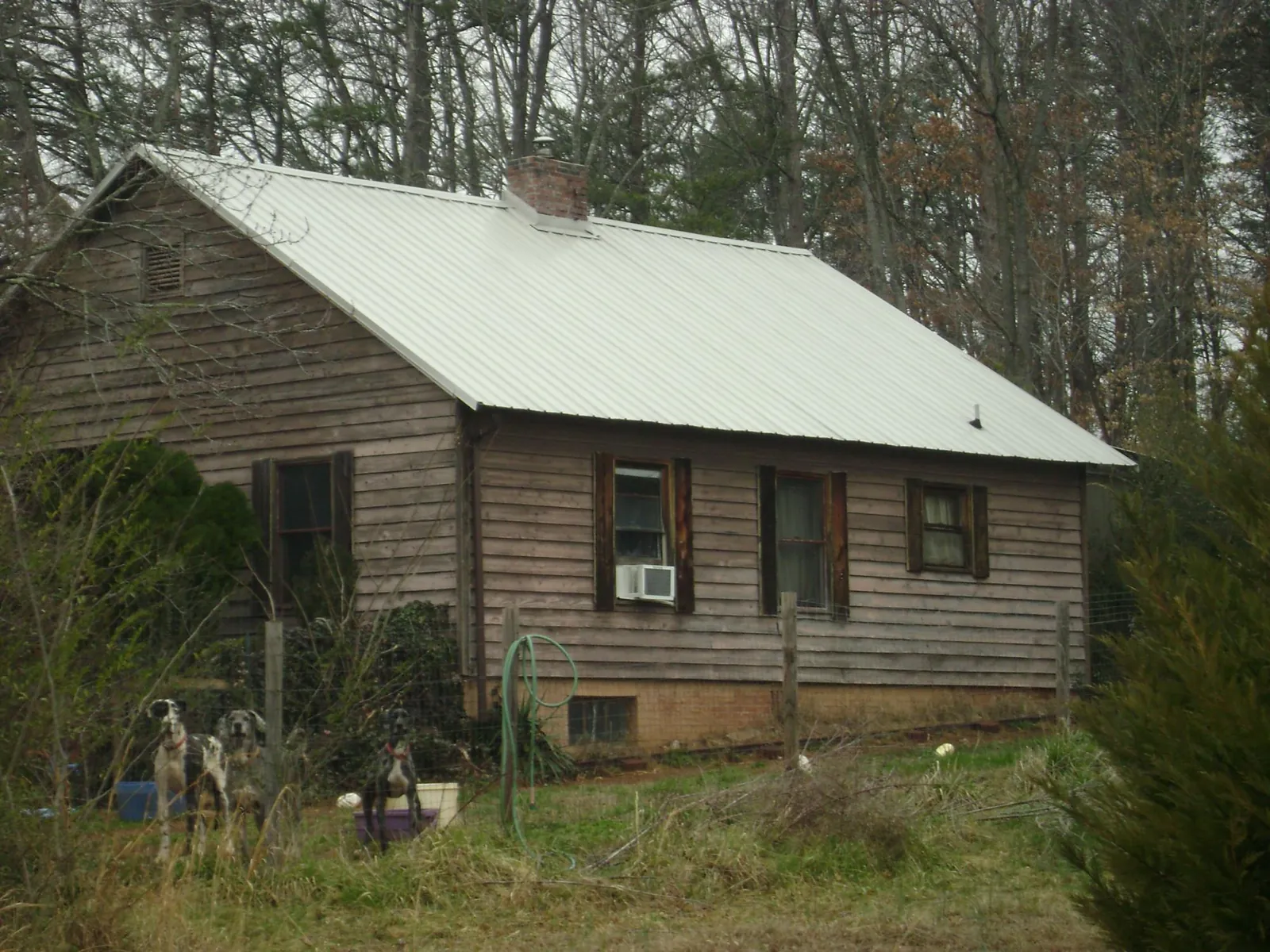 White metal roof on an old wood sided farmhouse, from a Metal Roof Installation job in Channelview